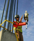 image of a seco heavy duty column clamp being used on a construction site, a geomax zoom90 robotic total station is being supported by the clamp